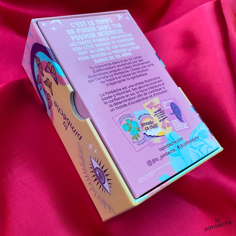 Close-up of the Badass Manifestor oracle cards. The back of the pack is shown. It is set against a pink background.